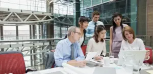 Management team looking at reports on monitor